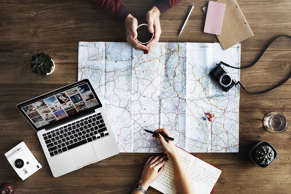 Trip planning with map, laptop and travel documents